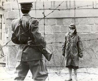 East german guard jumping the fence